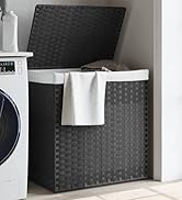 Grand panier à linge tissé foncé avec couvercle à côté d'une machine à laver blanche. Serviette blanche drapée sur le bord du panier