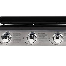 à trois brûleurs avec base en acier inoxydable et surface de cuisson noire. Comprend trois boutons de commande circulaires et un couvercle à charnière.