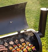 Gril extérieur avec capot ouvert montrant des brochettes grillées avec de la viande et des légumes à l'intérieur, sur fond vert. Équipement de gril en métal avec cuisson des aliments visibles à travers un capot transparent.