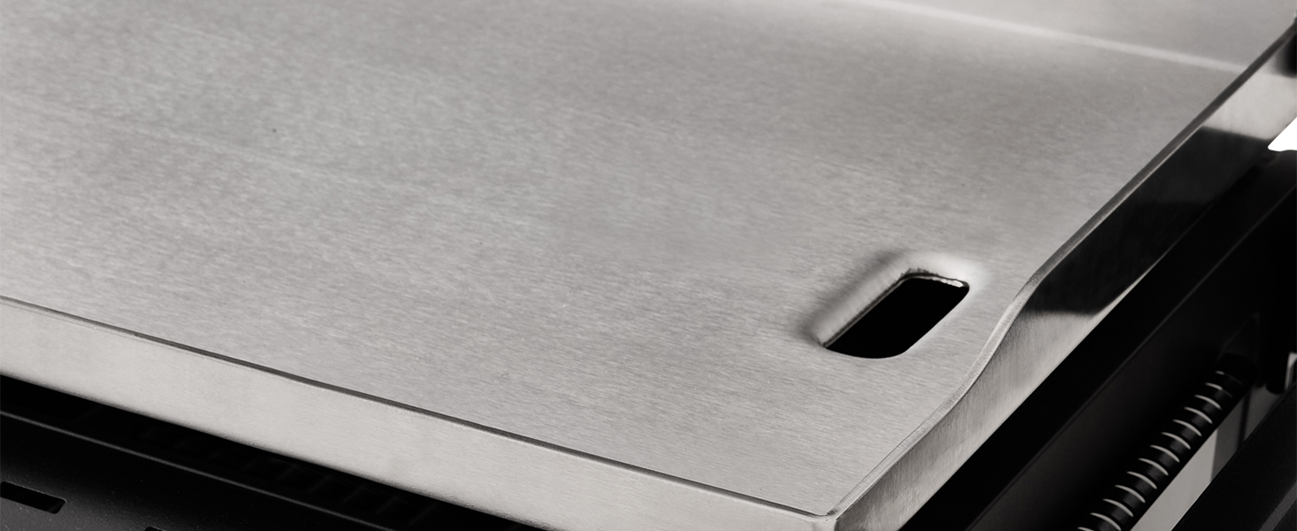 Gros plan de ce qui semble être une surface métallique ou en acier brossé avec une texture subtile et un petit élément sombre visible dans le coin supérieur.