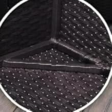 Vue circulaire aérienne d'un tapis ou d'un tapis noir à motif texturé en pointillé sur un plancher en bois, avec un design de compartiment triangulaire.