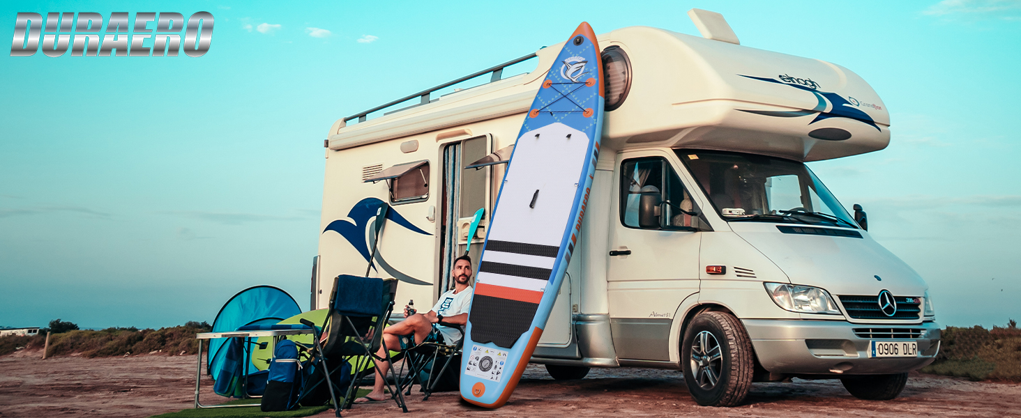 garé à l'extérieur avec planche à pagaie gonflable, chaise de camping et autres équipements de plein air. La scène présente un véhicule récréatif pour le camping et les activités nautiques